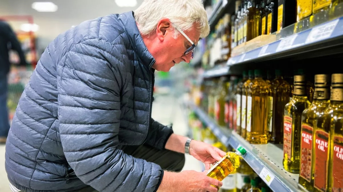 senior-man-looking-at-olive-oil-in-herb-product-shop-merseh.webp